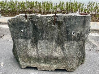 An old concrete barrier at the roadside typically acts as a protective divider, preventing vehicles...