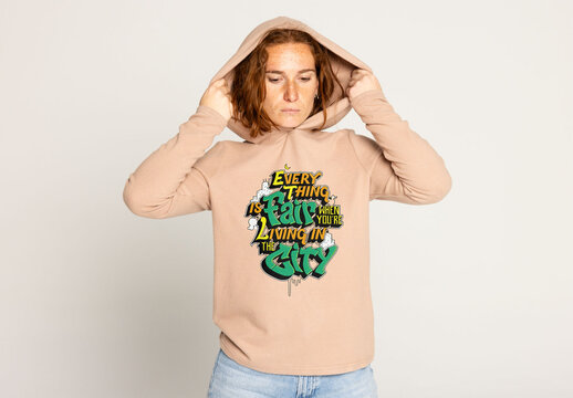 Redhead Woman in a Hooded Sweater Showcasing a Logo Mockup. Note: jumper&acute;s color cannot be changed.