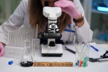 A dedicated scientist is meticulously examining various samples under a microscope in a specialized...