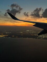 Fototapeta premium Airplane window view of sunset overlooking Doha, Qatar