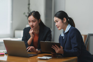 Businesswomen working together using laptop and documents in office