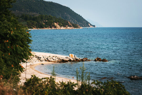 Tranquil Beach with Rocky Shoreline and Lush Hills