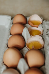 Overhead view of three cracked open eggs sitting in full carton
