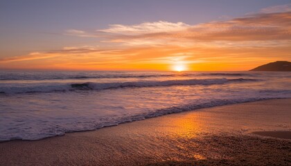 A golden sunset over the ocean, with gentle waves washing onto the shore, creating a peaceful and serene atmosphere.