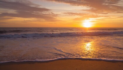 A golden sunset over the ocean, with gentle waves washing onto the shore, creating a peaceful and serene atmosphere.