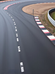 Motor racing track. A sleek, curving motor racing track with smooth asphalt, sharp turns, and marked lines. Race track curve road.