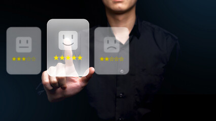 A person in a black shirt is interacting with a virtual rating interface, selecting a five-star rating with their finger. The digital elements glow on the screen.