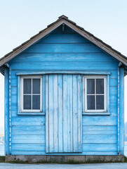 Charming blue wooden house with windows and rustic appeal
