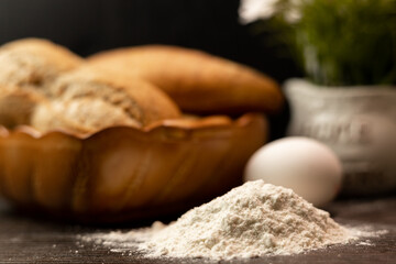 Flour, egg, rolling pin close-up.Bread in clay plate.The process of making bread