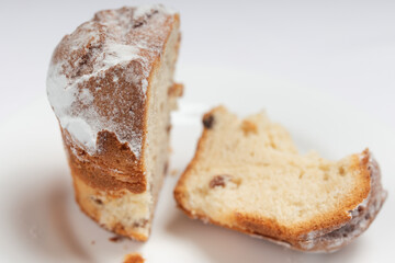 Close-up of a raisin cake with a crispy crust and fluffy inside, dusted with powdered sugar.