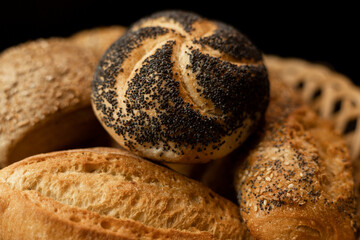 Freshly baked bun with poppy seeds. Assorted fresh pastries. Bread in a basket