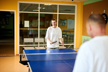 Two people playing table tennis. Man and woman compete in ping pong club