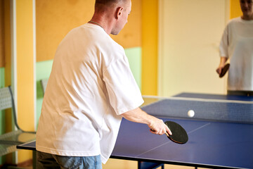 Two people playing table tennis. Man and woman compete in ping pong club