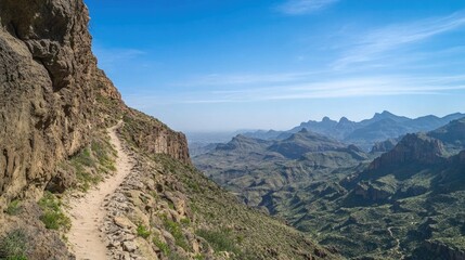 Obraz premium Winding path along rocky cliffs reveals breathtaking mountainous
