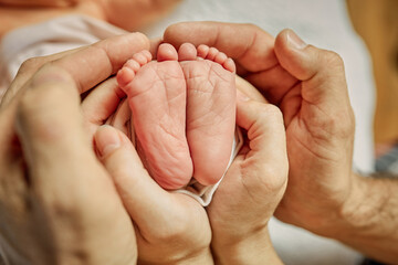 Mom and dad hugging newborn's feet.