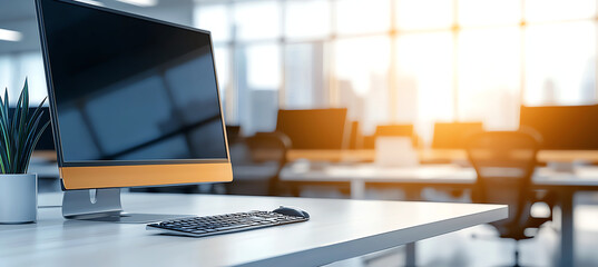 Modern office with computer and keyboard on desk, featuring plant. bright sunlight streams through large windows, creating warm atmosphere