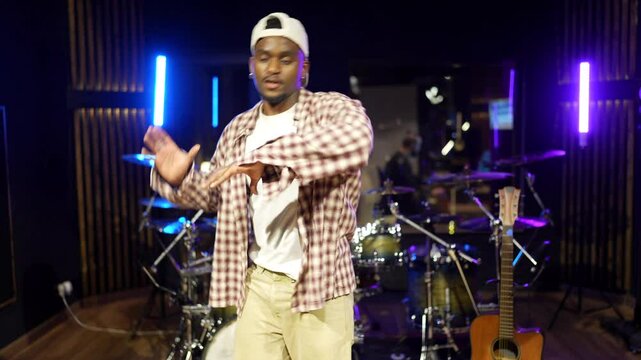 Talented black dancer and musician rehearsing urban dance moves in a music studio, showcasing his skills and passion for rhythm and movement