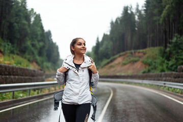 Charming caucasian woman hiking alone among mountains with backpack