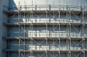Metal scaffolding frame on building wall. Framework construction site with scaffolding, steel pipes. Assembling structure for building industry. Construction engineering equipment. Urban architecture