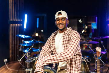 Young male musician dancing and enjoying music creation in recording studio