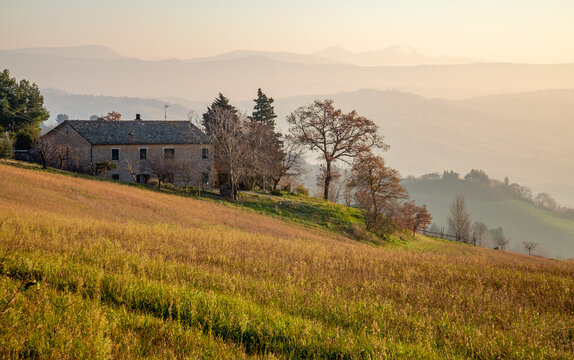 A house on the road between Mondaino and Belvedere Foglience, on the border between Emilia Romagna and Marche, Italy. View of the Montefeltro hills before sunset