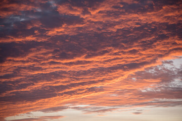 Fiery sunset clouds paint the evening sky in brilliant hues
