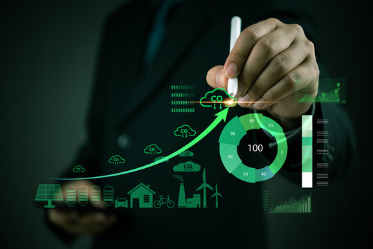 Businessman analyzing carbon footprint reduction with a futuristic dashboard. Concept of sustainability, renewable energy, CO2 emissions management, and environmental responsibility in business.