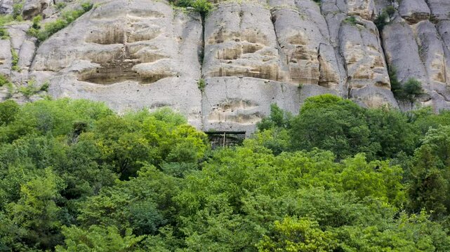 Approaching drone shot of the rock face of Madara Plateau Near showing the rock relief of the Madara Rider or Madara Horseman in Bulgaria.