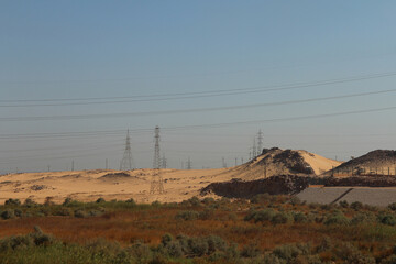 Scenery view of Aswan with transmission towers and desert along the road in sunny day, Egypt