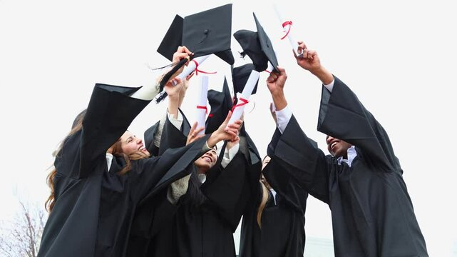 Happy graduates throwing graduation caps in the air