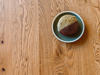 Delicious chocolate cookies with hazelnuts, half glazed, on a light wooden table, top view. Space for text.