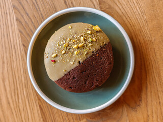 Delicious chocolate cookies with hazelnuts, half glazed, on a light wooden table, top view. Space for text. Part of the series.