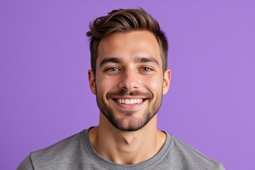Obraz premium Cheerful and Handsome Young Caucasian Male with Stylish Hair Smiling Against a Soft Purple Background, Exuding Confidence and Approachability