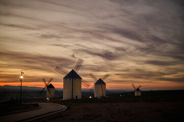 Sunset over the windmills of Campo de Criptana, casting a golden glow on the iconic landscape of...