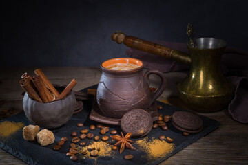 Homemade coffee with cookies and cinnamon on a dark table