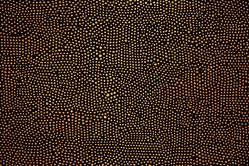 a close up of a black and gold background with small dots
