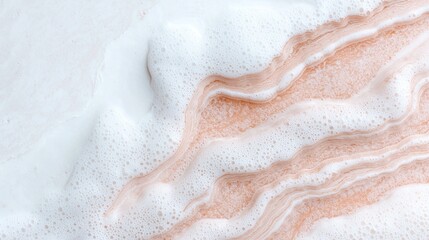 Fototapeta premium White soap foam and bubbles flowing over a textured peach surface in a clean studio setting.