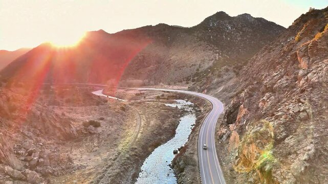 sunrise on mountain peaks unveiling a lonely highway through Bighorn Canyon, by the Arkansas river