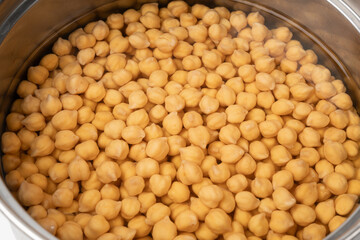 Soaked chickpeas, chick pea in water, swollen wet Cicer arietinum fruits, garbanzo beans cooking