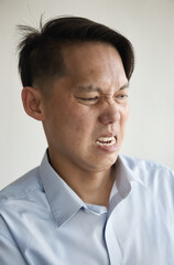 Fearful and scared off asian middle aged man showing stop and no way hand gesture, trying to stay away from something