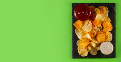Perfectly fried and seasoned potato chips with creamy white and tangy red dip, served on a modern...