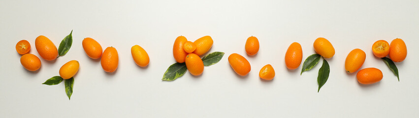 Kumquat and leaves on white background, top view
