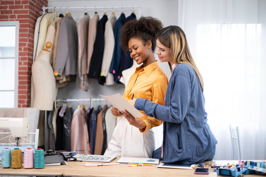 College women fashion designer stylish stand and working with color textile samples.Attractive lady team works at fashion studio.