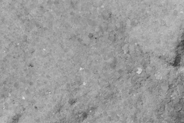 Obraz premium Detailed close-up of a rough white marble surface with natural dark veins and grainy texture. The stone has an organic appearance with slight imperfections.