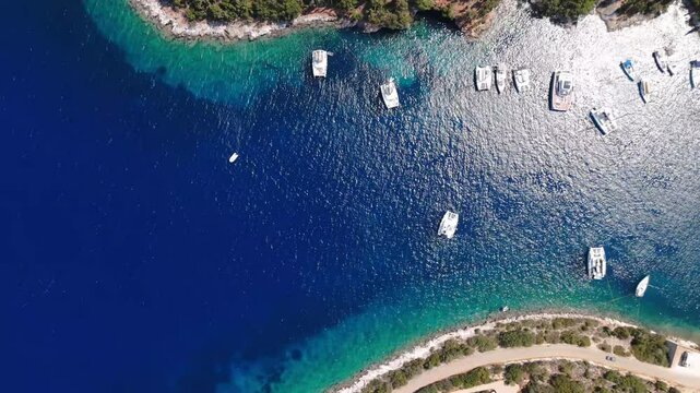 Aerial establishing of Foki Beach, Kefalonia, Greece, with anchored boats in turquoise waters