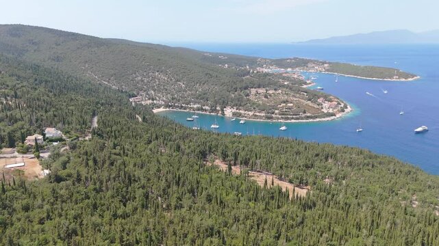 Aerial estabilshing approach to Foki Beach, Kefalonia, Greece, peaceful bay and scattered boats