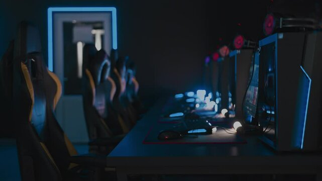 Modern cyber computer club for videogames and E-sport tournament. Gaming armchairs, mouses and keyboards with RGB lighting animation, mats. LAN cafe. No one, nobody. Handheld shot