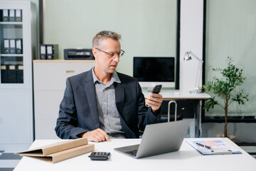 Professional businessman working at office with laptop, tablet, and notes. Perfect for business, finance, accounting