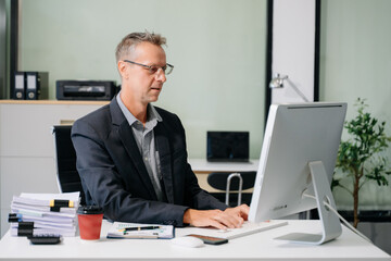 Fototapeta premium Professional businessman working at office with laptop, tablet, and notes. Perfect for business, finance, accounting
