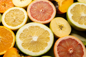 Fototapeta premium A close up of several different colored oranges and grapefruits. The oranges are sliced open and the grapefruits are cut in half. Concept of abundance and variety, as well as the freshness
